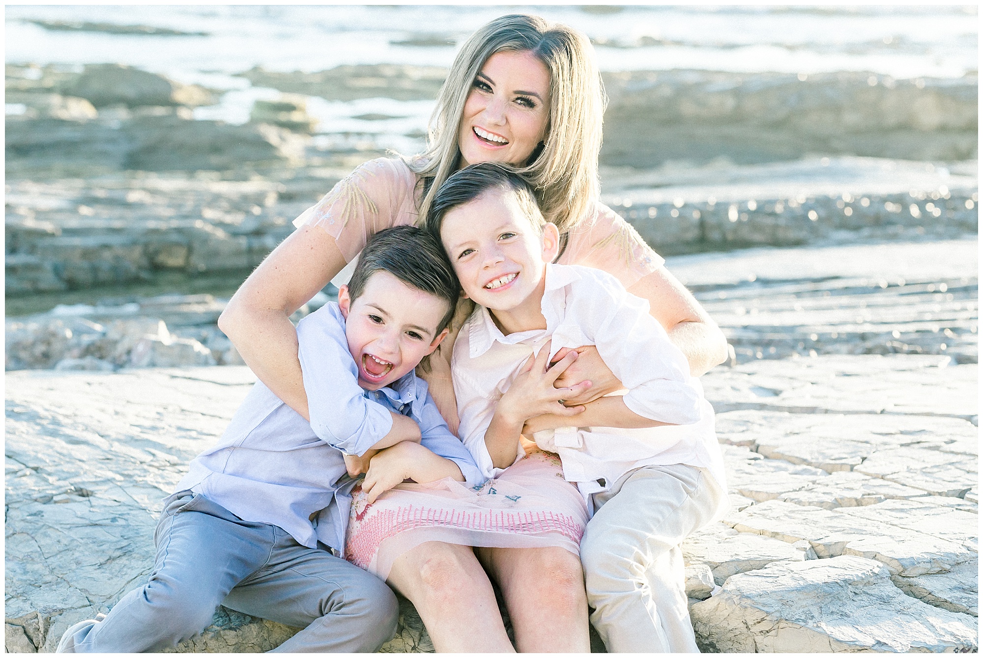 Mom and two boys laughing and snuggling at sunset beach photo session